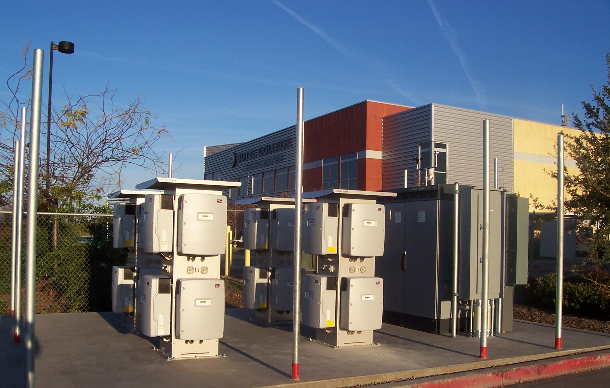 Mid-construction, inverters await fencing to enclose them from passing students.